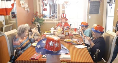Residents celebrating with festive hats at a dining table