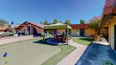 Outdoor seating area with canopy and green landscaping