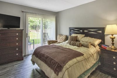 Cozy resident room with bed and private patio access