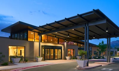 Exterior view of a senior living facility entrance at dusk