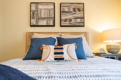 Comfortable bedroom setup with decorative pillows and art