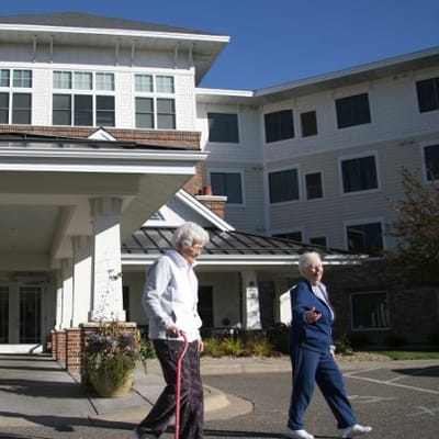Two residents walking outside the facility
