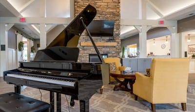 A cozy lounge area featuring a grand piano and seating