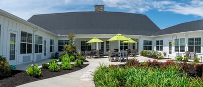 Outdoor patio area with green umbrellas and landscaping