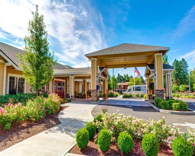 Welcoming entrance of Washington Gardens Memory Care surrounded by gardens