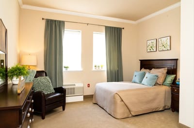 Cozy private resident room with a bed and seating