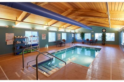 Indoor pool area with wooden ceiling and seating