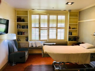 Private resident room with a hospital bed and seating area