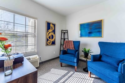 Brightly lit lounge area with chairs and art