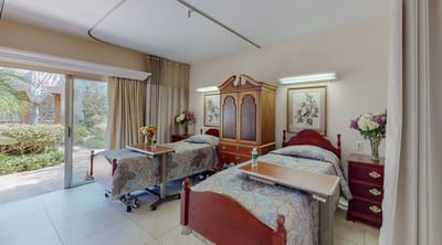 Brightly furnished resident room with two beds and outdoor view
