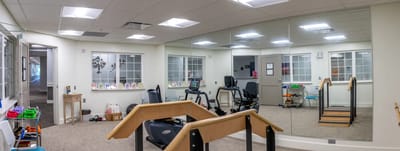 Rehabilitation gym with exercise equipment and mirrors