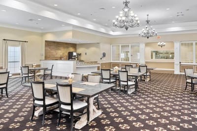 Bright dining room with tables and chairs set for residents