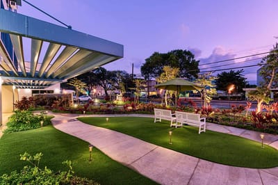 Outdoor space with a pathway and seating area at dusk
