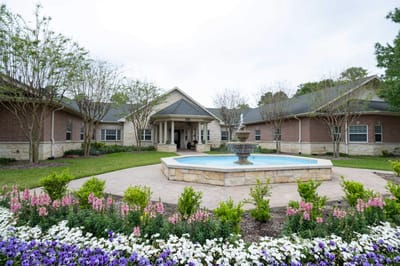 Exterior view of the facility with a fountain and flowers
