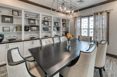 Modern dining area with large table and decorative shelves