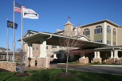 Front entrance of the assisted living facility with flags