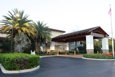 Entrance of a senior living facility with palm trees