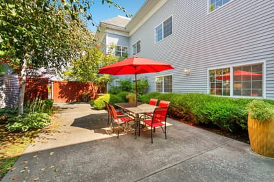 Outdoor seating area with a red umbrella and chairs