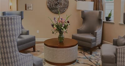 A cozy common area with seating and floral arrangement