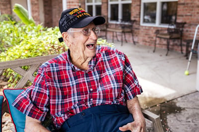 Senior resident smiling outdoors in casual attire