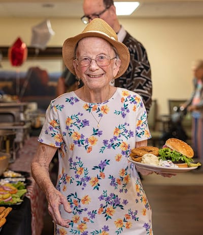 Resident enjoying a meal in a communal dining space