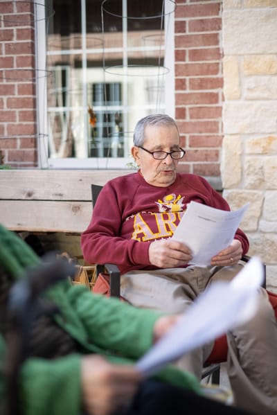 Resident reading documents in an outdoor space