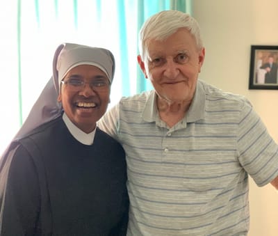 A staff member and resident smiling together indoors