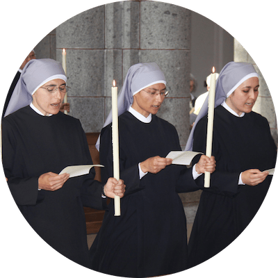 Sisters participating in a ceremony with candles