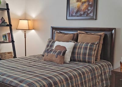 Cozy bedroom setup with plaid bedding and lamp