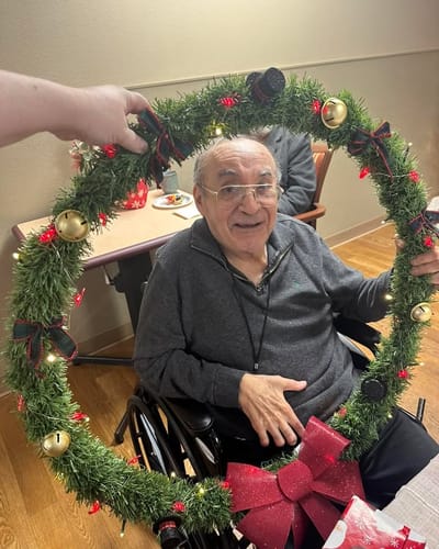 Resident holding a festive wreath during holiday activities