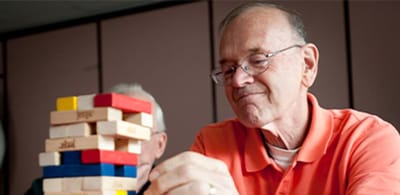 Resident playing a game of Jenga with a friend