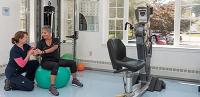 Senior resident engaging in physical therapy with staff