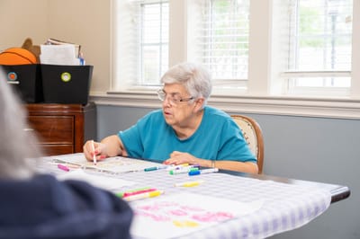 A resident engaging in an art activity at a table