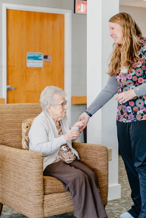 Staff member interacting with a resident in a cozy interior