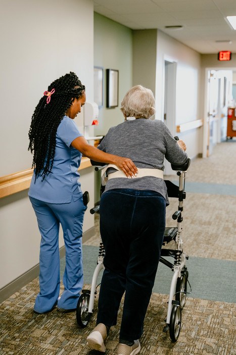 Staff assisting a resident in a corridor