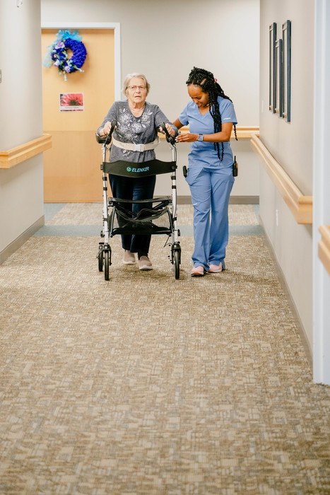 Staff assisting a resident in a hallway