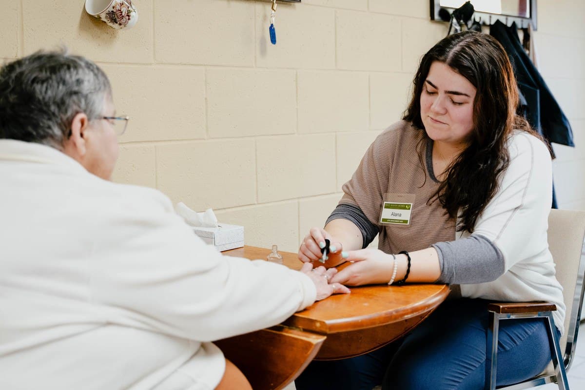 Resident receiving a manicure from staff member