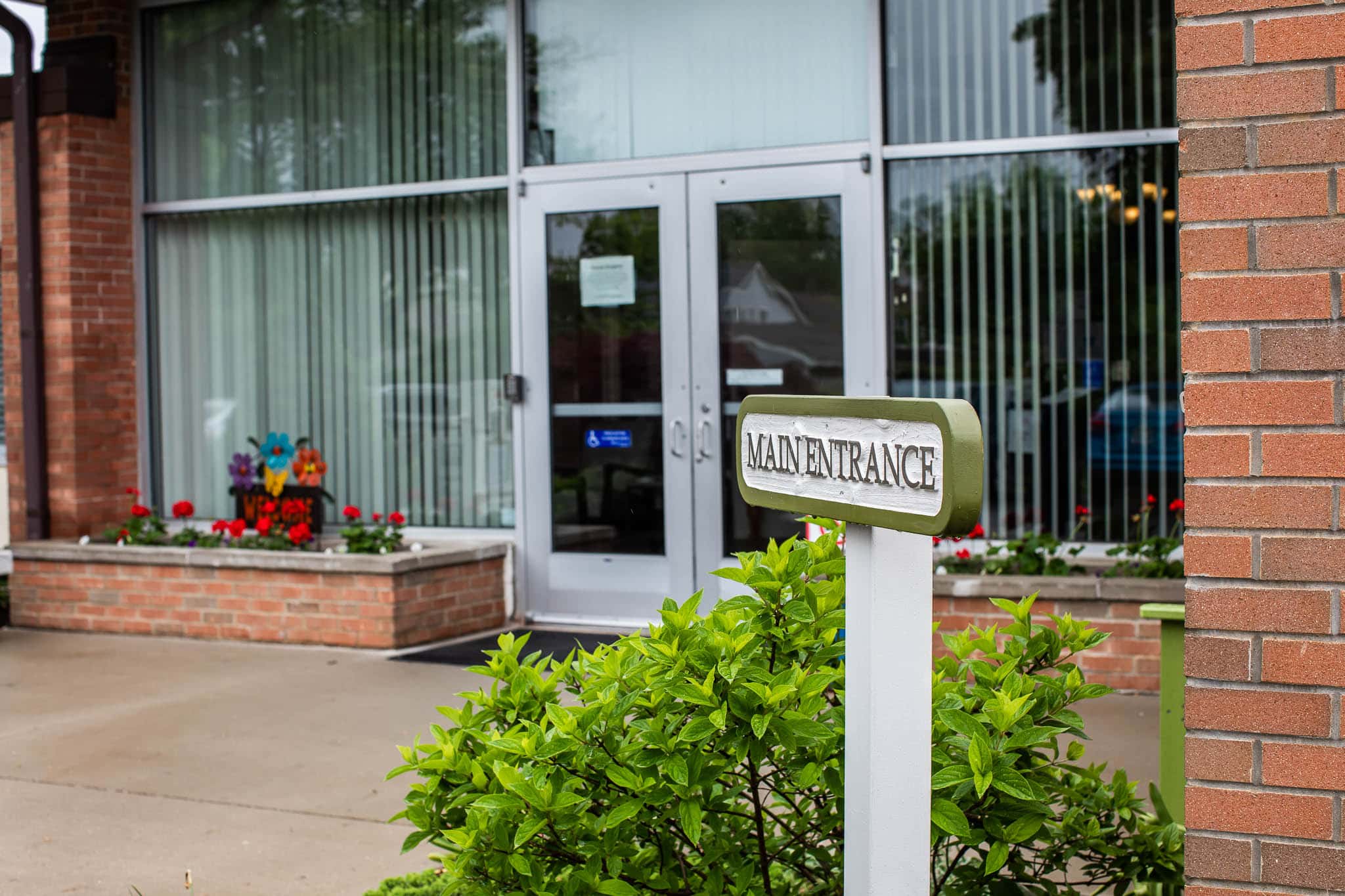 Entrance sign for Rest Haven Homes with landscaping