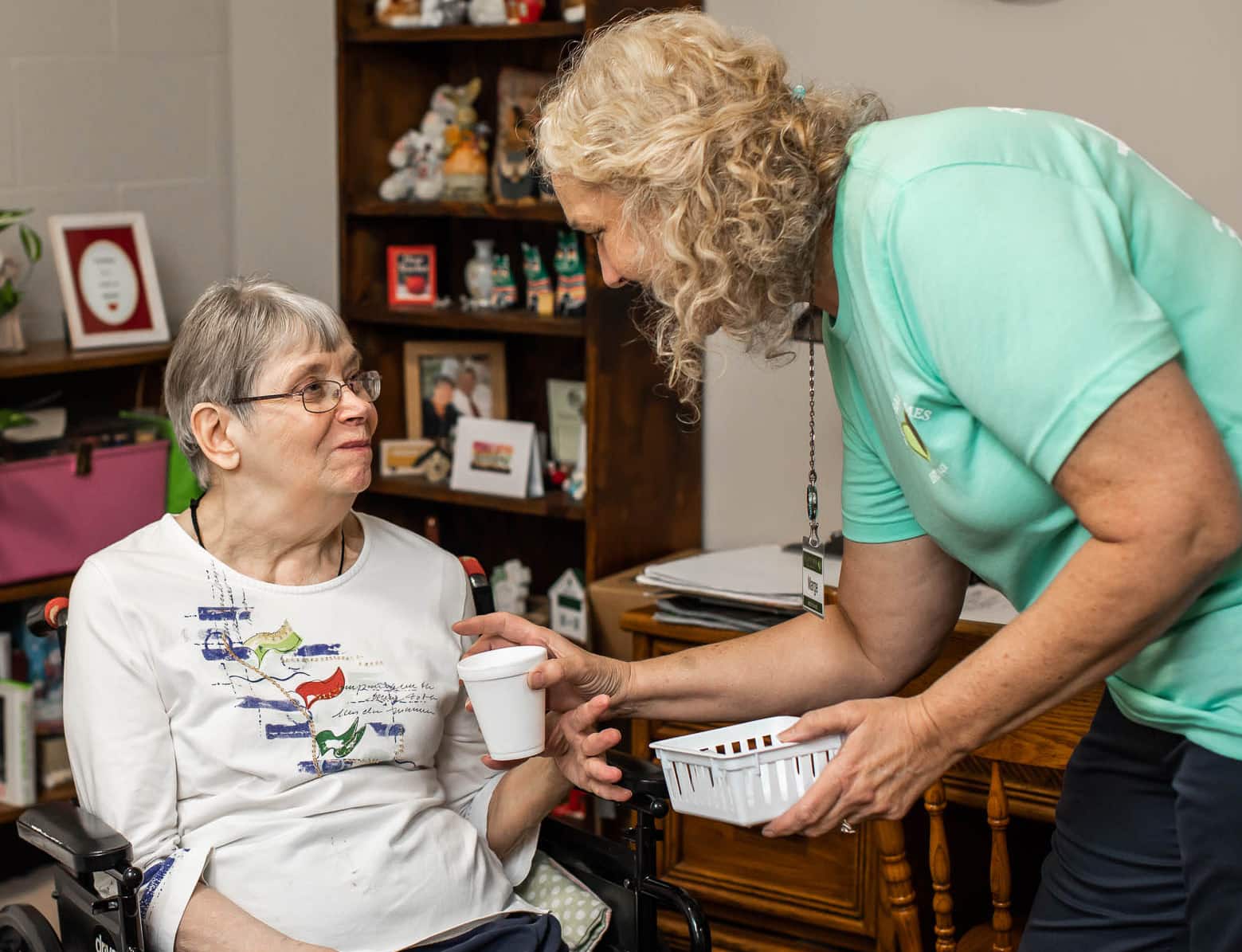 Staff assisting a resident in a cozy interior setting