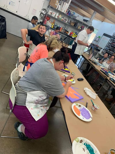 Residents engaged in an art activity in a bright room