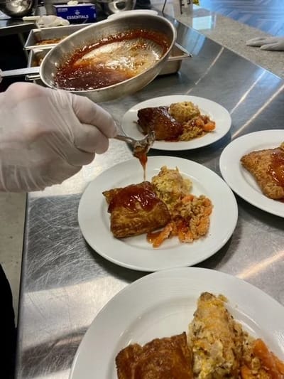 Staff plating a meal in the kitchen