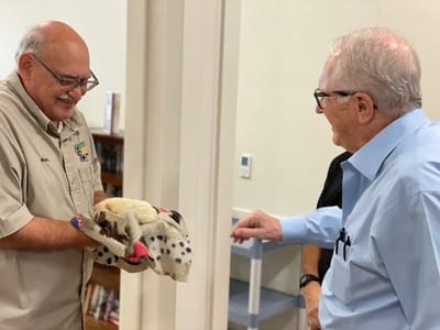 Staff member presenting a blanket to a resident