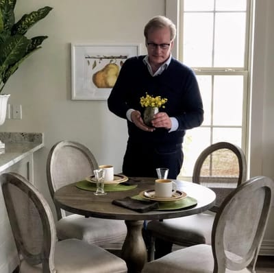 A staff member setting a dining table in a bright room