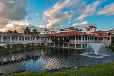 Exterior view of a senior living facility by a pond