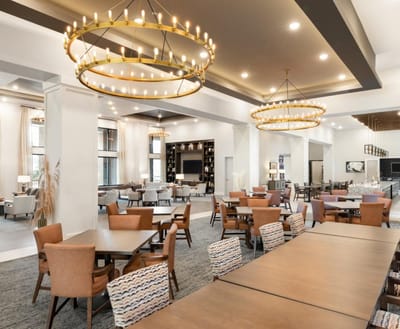 Bright and spacious common area with dining tables