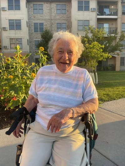 A resident smiling in a garden area