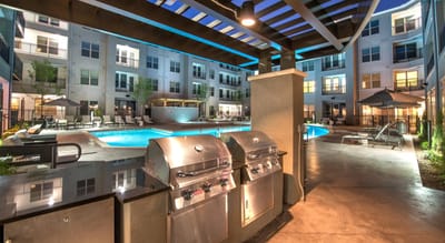 Outdoor pool area with lounge chairs and grill