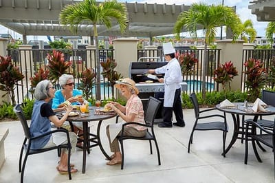 Residents enjoying lunch outdoors by the pool