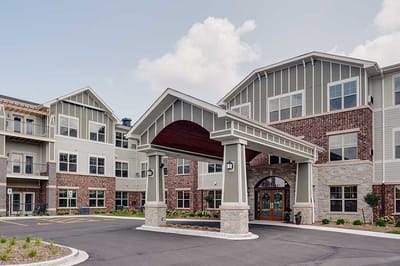 Exterior view of a senior living facility with a covered entrance