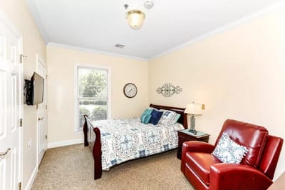 Cozy resident room with bed and chair